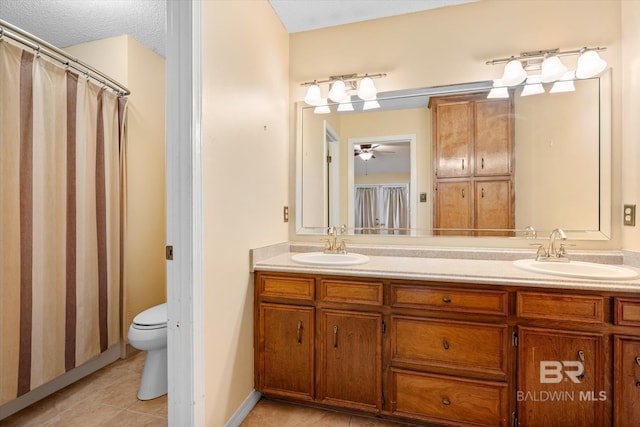 bathroom with ceiling fan, tile patterned flooring, a textured ceiling, toilet, and vanity