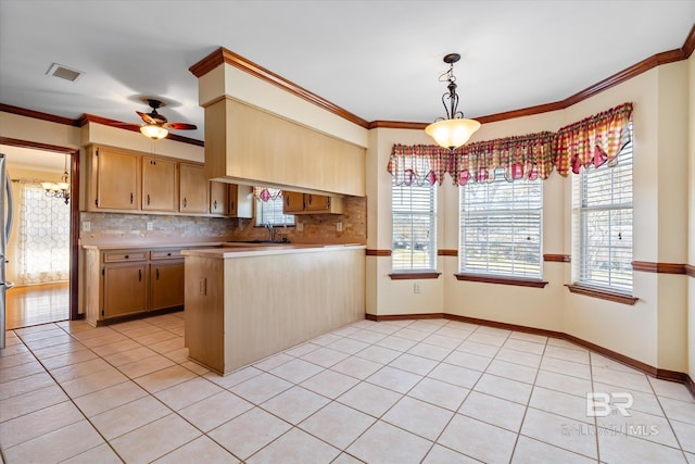 kitchen featuring decorative light fixtures, ceiling fan, kitchen peninsula, and crown molding