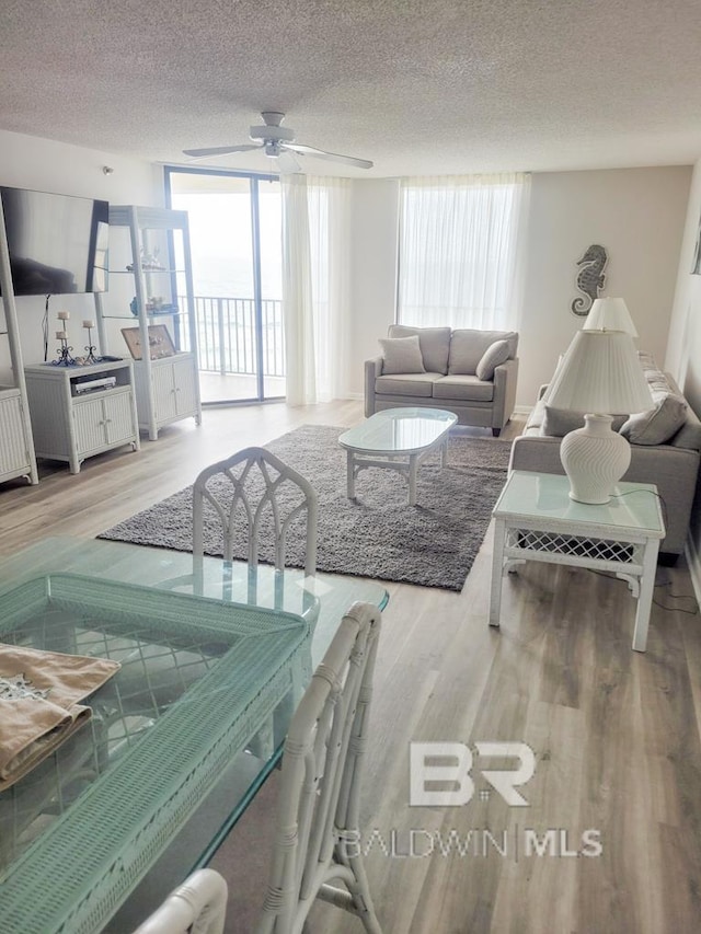 24250 Perdido Beach Blvd Unit 4603, Orange Beach, AL 36561 - living area with a ceiling fan, wood finished floors, a textured ceiling, and a wall of windows
