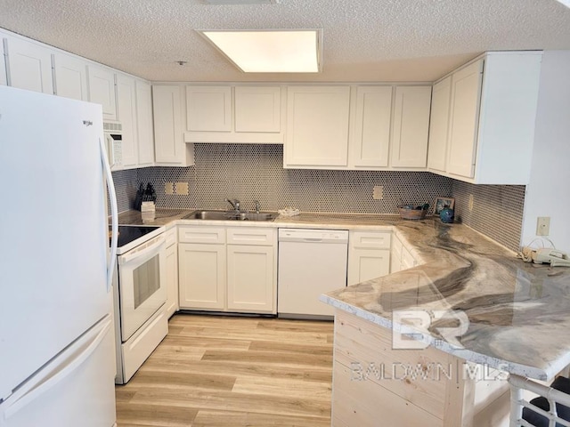24250 Perdido Beach Blvd Unit 4603, Orange Beach, AL 36561 - kitchen with white appliances, a peninsula, light wood-type flooring, decorative backsplash, and a textured ceiling