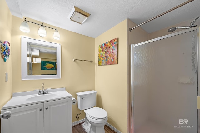 bathroom with toilet, an enclosed shower, a textured ceiling, vanity, and hardwood / wood-style floors