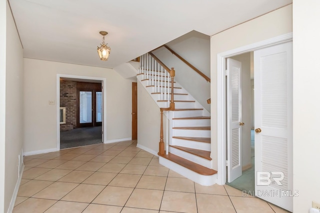 stairs featuring baseboards and tile patterned floors