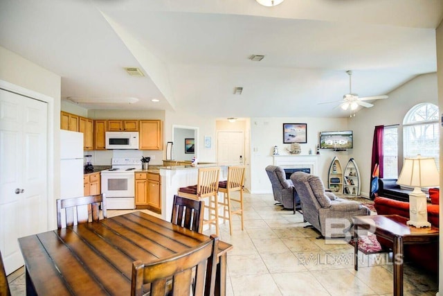 tiled dining area featuring lofted ceiling and ceiling fan