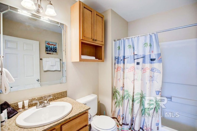 full bathroom featuring shower / tub combo with curtain, vanity, and toilet