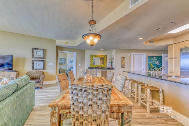 dining space featuring light hardwood / wood-style flooring and sink