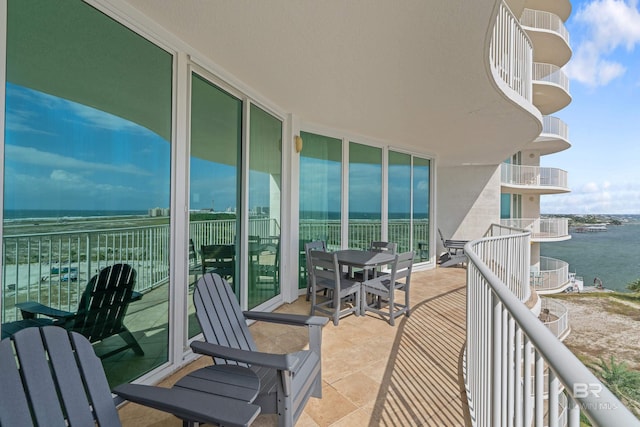 balcony featuring a water view and a beach view