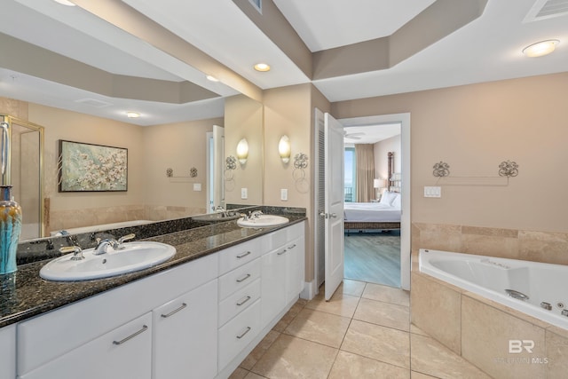 bathroom with vanity, a relaxing tiled tub, and tile patterned floors