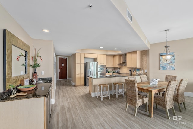 dining room featuring sink and light hardwood / wood-style floors