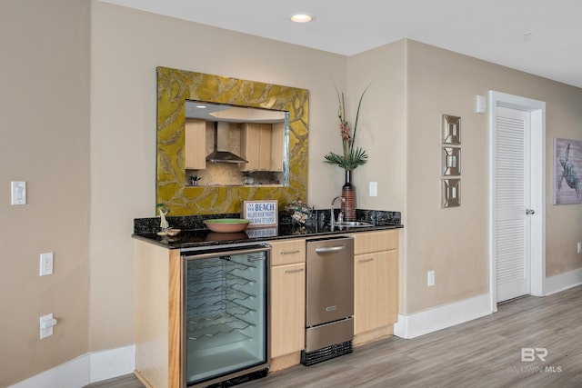 bar with wall chimney range hood, wine cooler, light brown cabinetry, light hardwood / wood-style floors, and sink