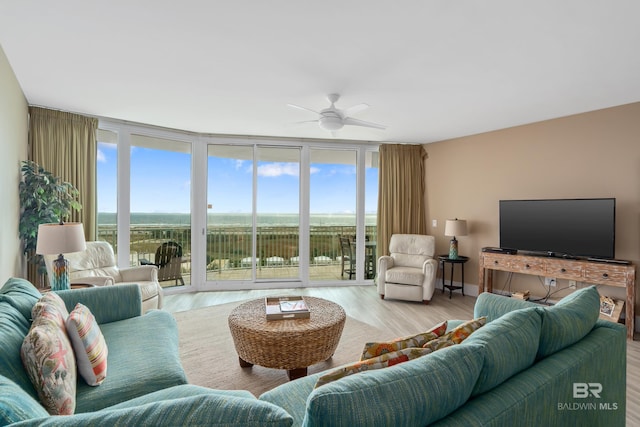 living room featuring a wall of windows, light hardwood / wood-style flooring, and ceiling fan