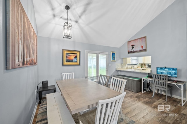 dining area featuring vaulted ceiling, a notable chandelier, and dark hardwood / wood-style flooring