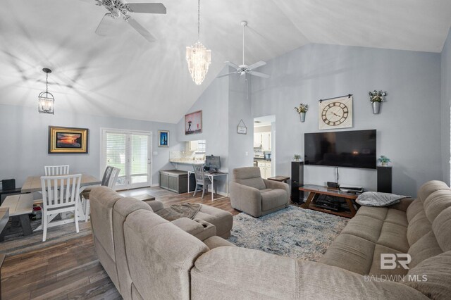 living room with ceiling fan with notable chandelier, high vaulted ceiling, and dark hardwood / wood-style flooring