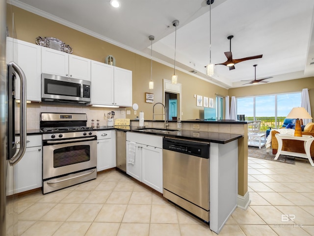 kitchen featuring white cabinets, decorative light fixtures, stainless steel appliances, sink, and kitchen peninsula