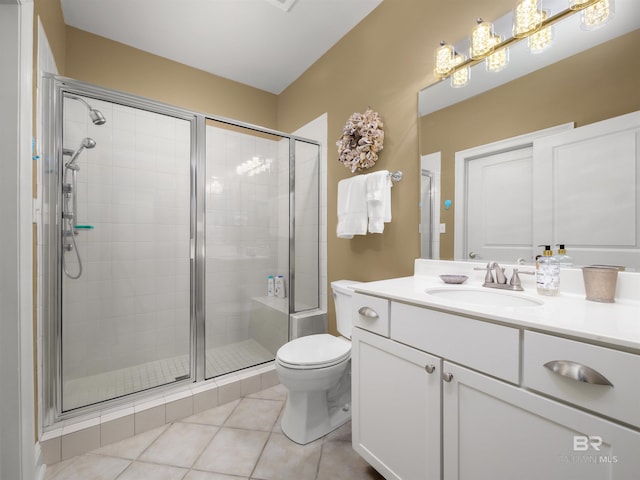 bathroom with an enclosed shower, vanity, tile patterned flooring, and toilet