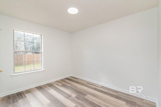 unfurnished room with light wood finished floors and baseboards