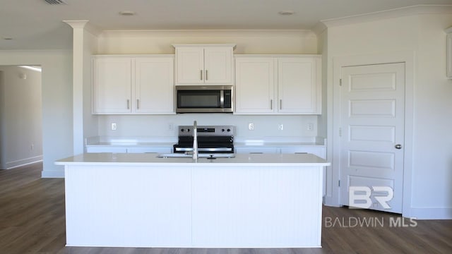 12681 Shoshoney Cir, Fairhope, AL 36532 - kitchen featuring appliances with stainless steel finishes, ornamental molding, a kitchen island with sink, light countertops, and dark wood-type flooring