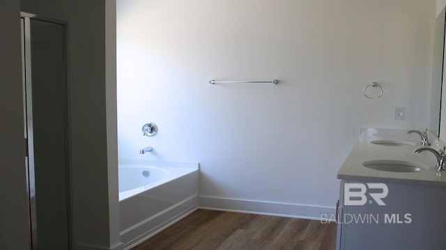 12681 Shoshoney Cir, Fairhope, AL 36532 - full bathroom with wood finished floors, double vanity, a bath, and baseboards