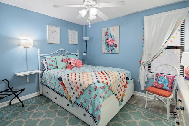 bedroom featuring hardwood / wood-style flooring, ceiling fan, and a textured ceiling