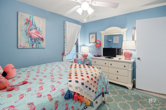 bedroom featuring ceiling fan and a textured ceiling