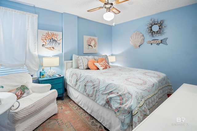 carpeted bedroom with ceiling fan and a textured ceiling