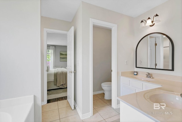 3677 Ashton Ct, Gulf Shores, AL 36542 - ensuite bathroom featuring toilet, tile patterned floors, vanity, a tub to relax in, and baseboards