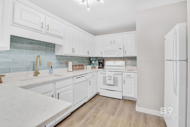 kitchen with sink, white appliances, light hardwood / wood-style floors, and white cabinets