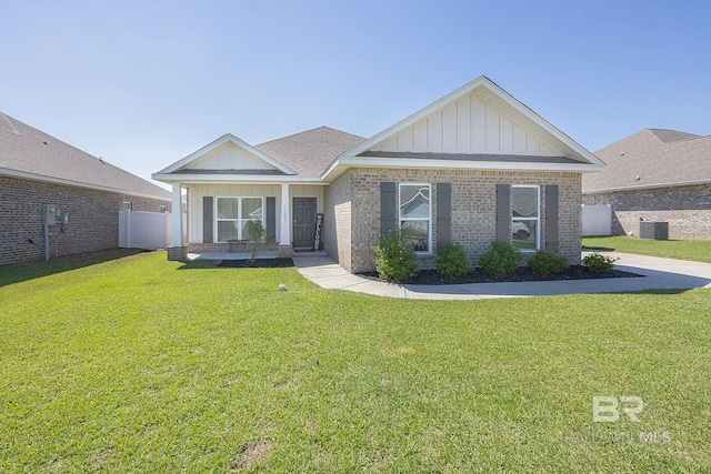 view of front of property with a front lawn and central air condition unit