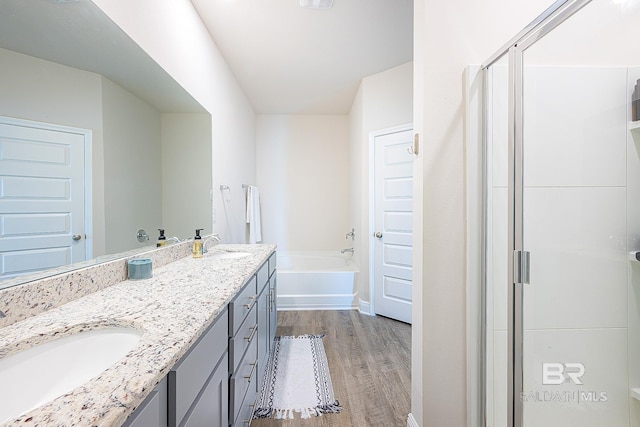 bathroom with shower with separate bathtub, wood-type flooring, and vanity