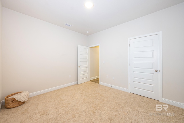 unfurnished room featuring light carpet