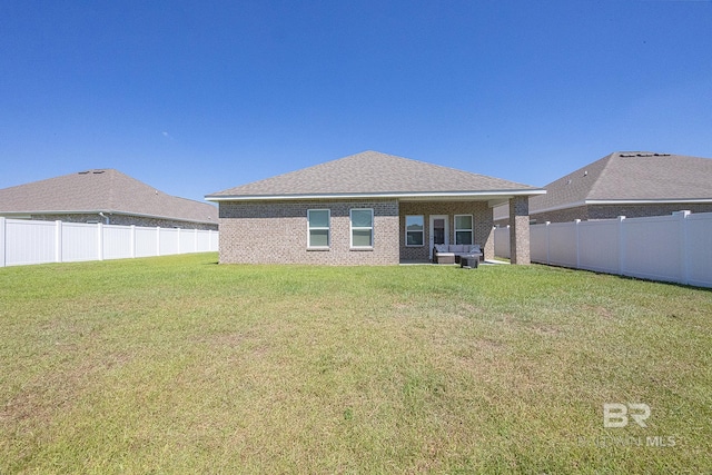 rear view of house with a lawn and a patio area