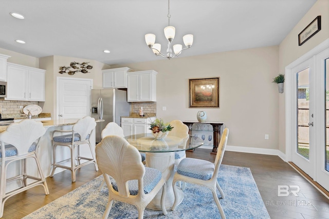 dining room with french doors, a healthy amount of sunlight, an inviting chandelier, and wood finished floors