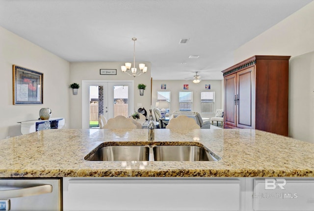 kitchen featuring visible vents, dishwasher, open floor plan, light stone countertops, and french doors