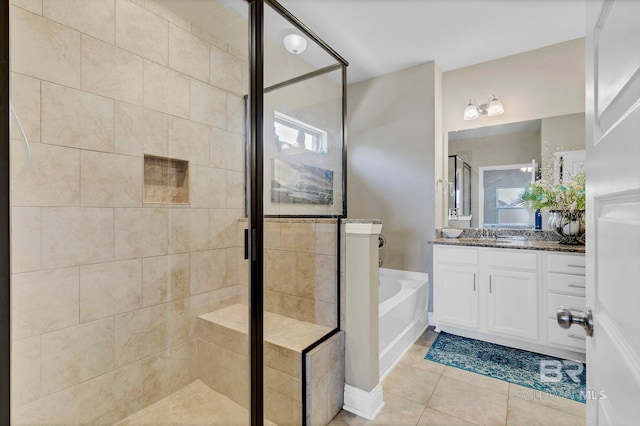 bathroom featuring a stall shower, tile patterned flooring, a garden tub, and vanity