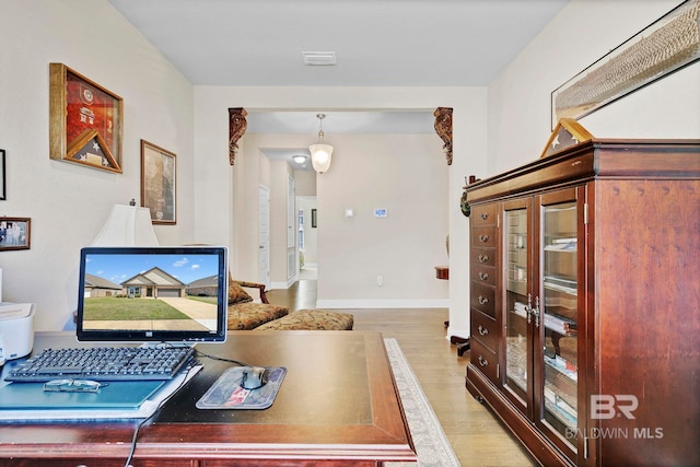 office space featuring baseboards, visible vents, and light wood-style floors