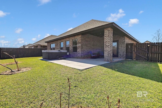 rear view of house with brick siding, a hot tub, a fenced backyard, and a patio