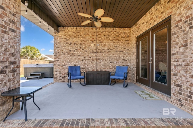 view of patio with a ceiling fan and a hot tub