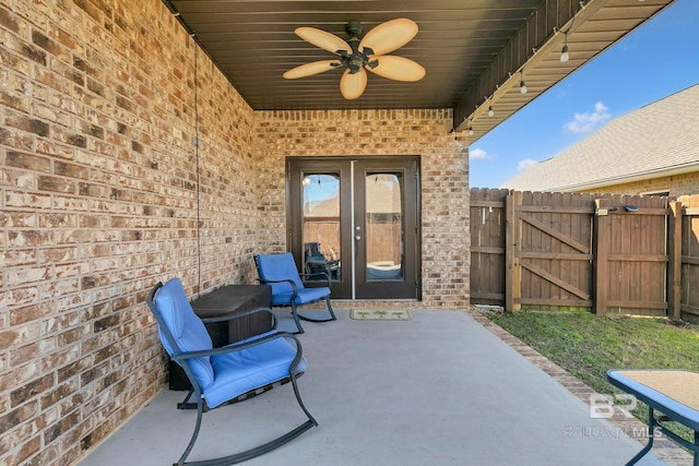 view of patio featuring a gate, fence, and a ceiling fan