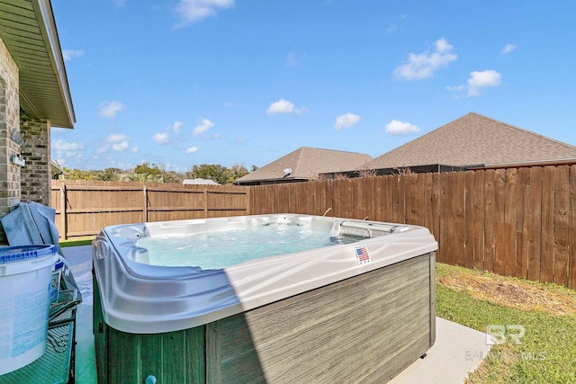 view of swimming pool with a fenced backyard and a hot tub