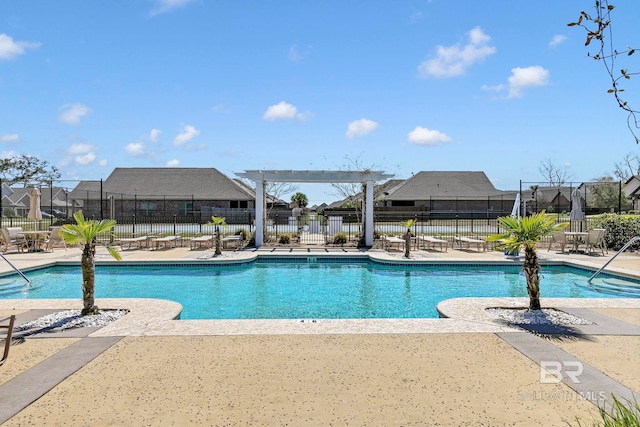 community pool featuring a residential view, a patio area, and fence