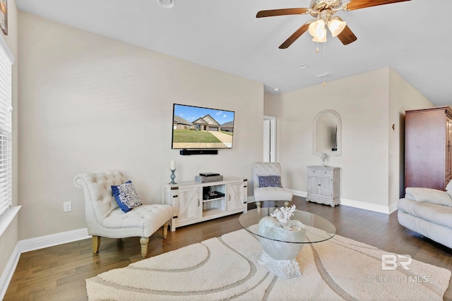 living room featuring ceiling fan, baseboards, and wood finished floors