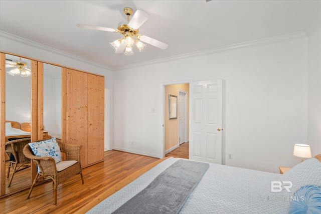 bedroom featuring baseboards, crown molding, a ceiling fan, and light wood finished floors