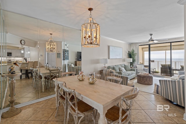 dining space featuring ceiling fan with notable chandelier, light tile patterned floors, and crown molding
