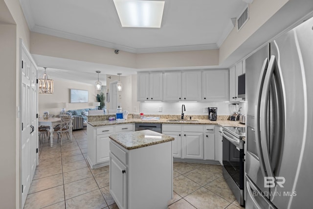 kitchen with crown molding, a sink, stainless steel appliances, a peninsula, and visible vents