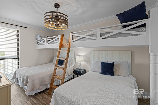 bedroom with wood finished floors, a notable chandelier, and ornamental molding