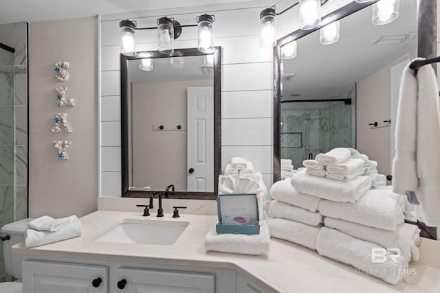 full bath featuring vanity, visible vents, and tiled shower