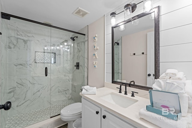 bathroom with toilet, vanity, visible vents, and a stall shower