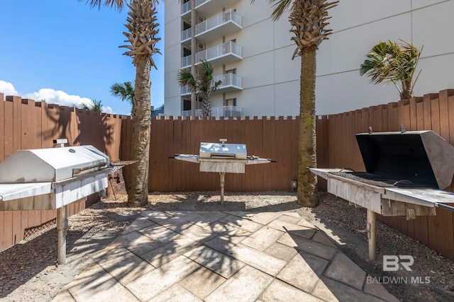 view of patio featuring a grill and fence