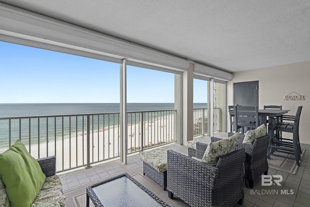 living area with tile patterned floors, a textured ceiling, and a water view