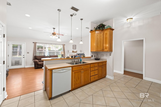 kitchen featuring dishwasher, sink, hanging light fixtures, kitchen peninsula, and light tile patterned flooring