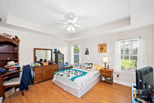 bedroom featuring ceiling fan, light wood-type flooring, and multiple windows